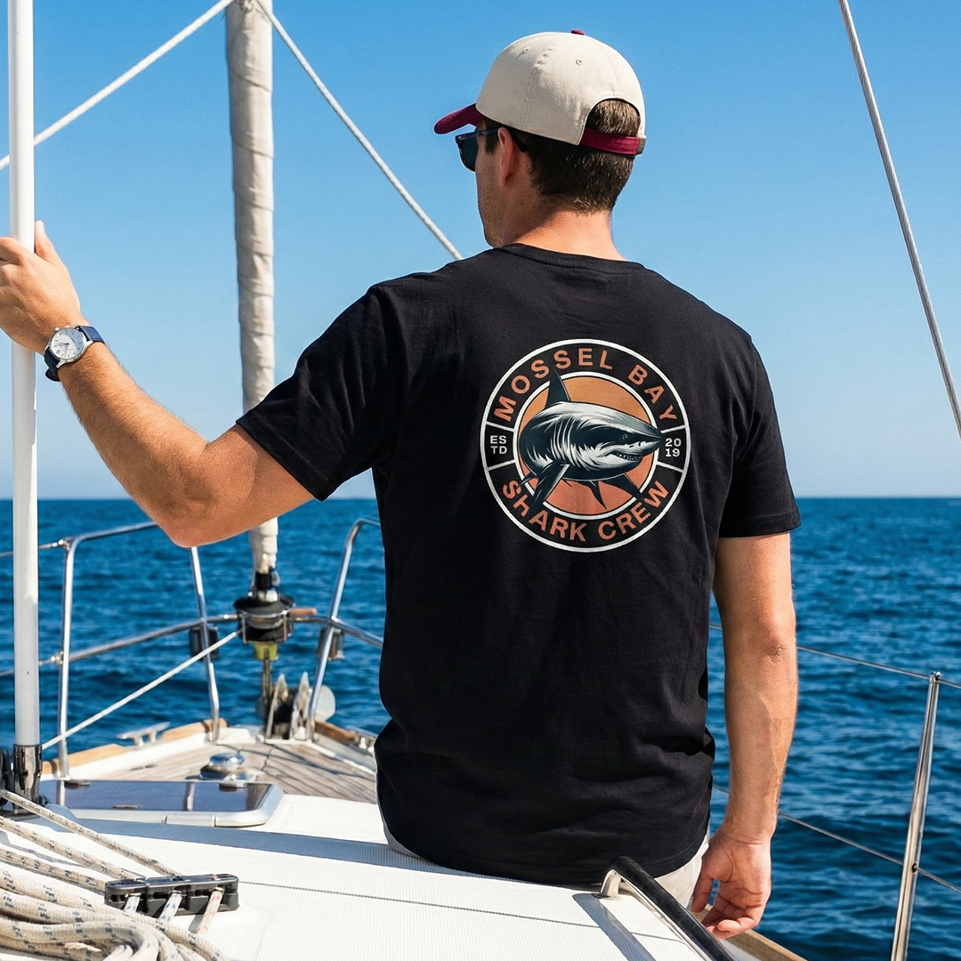 Man wearing shark graphic t-shirt on sailboat, marine adventure apparel