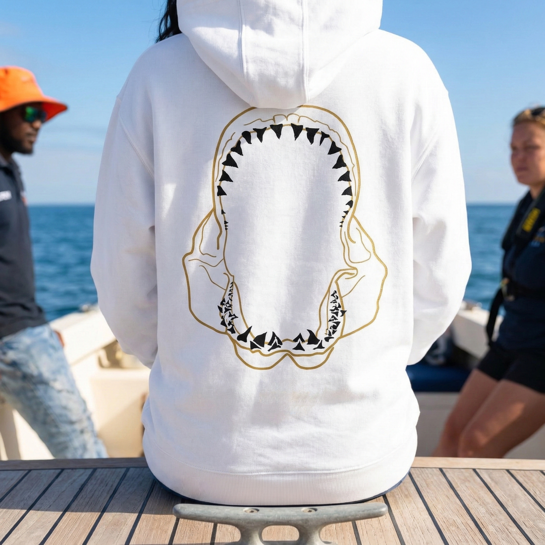 Person wearing a white hoodie with a shark tooth design on a boat