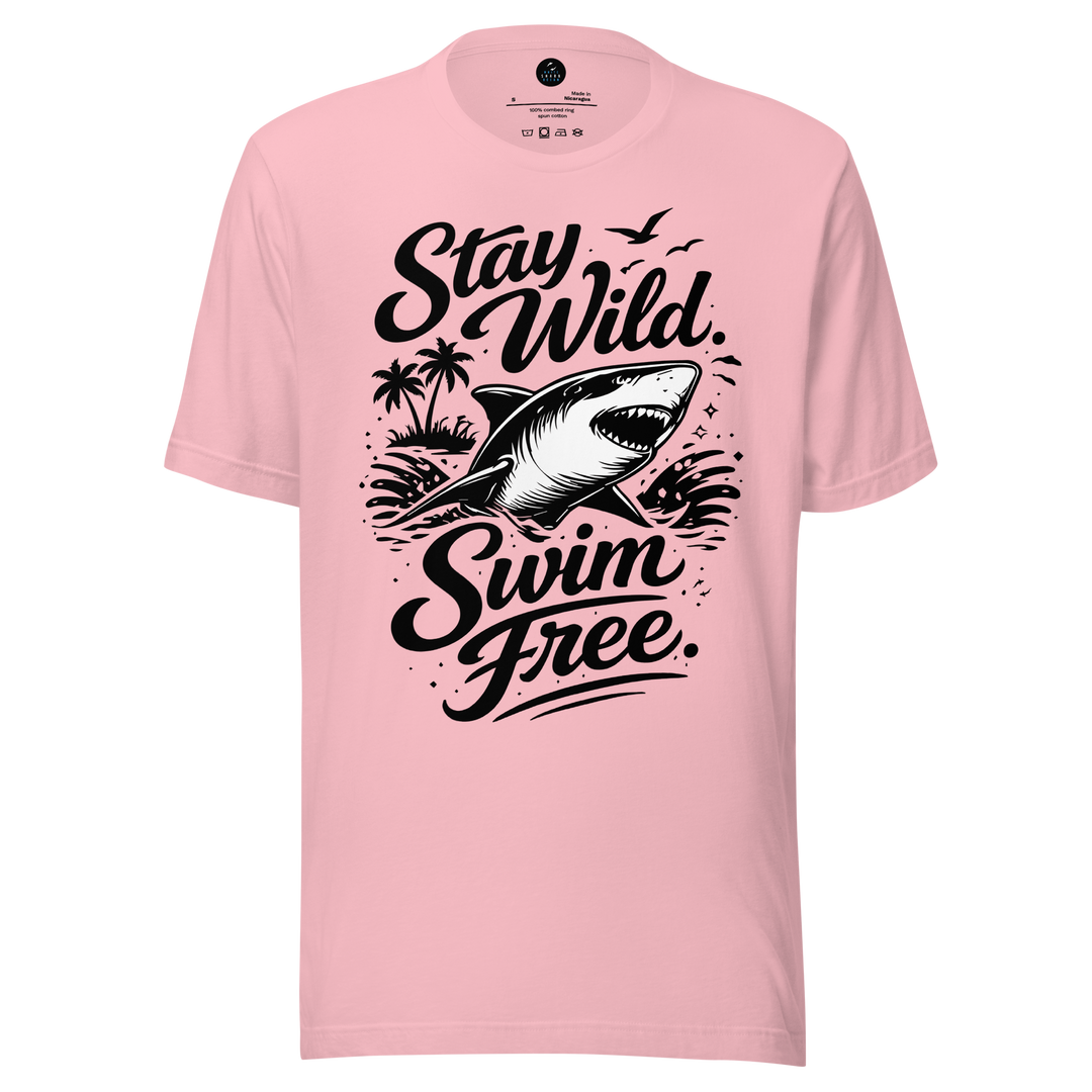 Pink t-shirt with a shark graphic and text 'Stay Wild Swim Free' on a white background