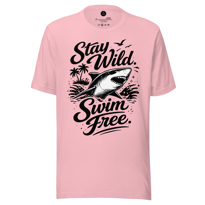 Pink t-shirt with a shark graphic and text 'Stay Wild Swim Free' on a white background